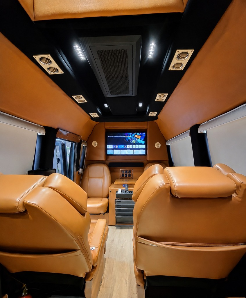 Caravan interior — reclining seats, screen and ceiling climate control